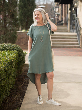 lightweight lagoon green linen dress with frayed ruffle sleeves worn with white tennis shoes