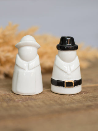 a pair of ceramic salt and pepper shakers in the shape of pilgrims perfect for thanksgiving decor gifts