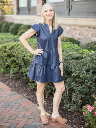 a dark blue faux leather tiered dress with puff cap sleeves perfect for casual chic dressing shown with slip on platforms