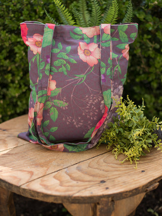 a floral tote bag in plum purple featuring long shoulder straps