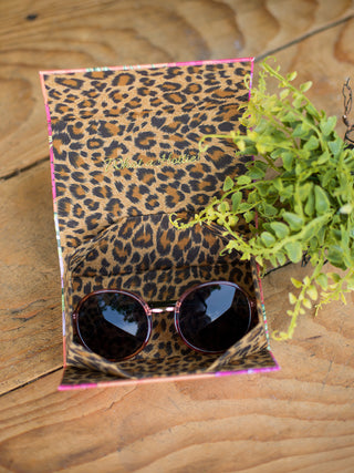 circular vintage shape sunglasses with rose colored frames inside its complimentary leopard print case