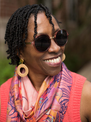 round frame vintage sunglasses in a tortoise shell pattern shown on smiling woman