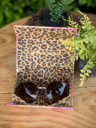 circular vintage shape sunglasses in a tortoise shell pattern inside its complimentary leopard print case