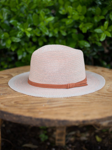 side view of wide brim apricot hat with an adjustable sizing rust ribbon in foldable fabric