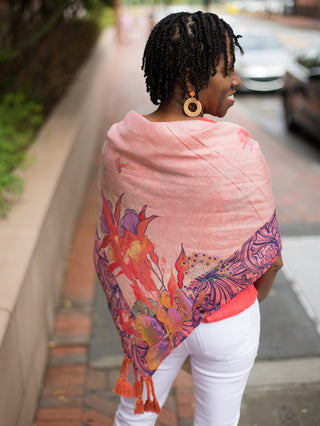 100% silk scarf with pink purple and orange hummingbirds and corner tassels shown draped across back