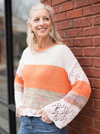 an orange and white colorblock crochet sweater with statement sleeves