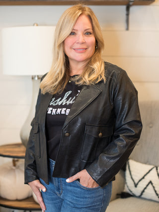 a black faux leather crop jacket with button closures great for layering in cold weather months
