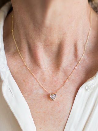 a valentines necklace with a rhinestone heart charm on a dainty gold chain