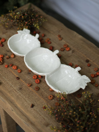 a white ceramic triple serving dish in the shape of three pumpkins perfect for fall decor gifts and halloween season