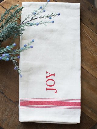 place this white and red tea towel that reads joy in your home as holiday decor or give as a hostess gift