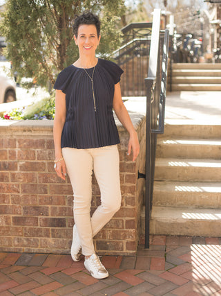 relaxed black satiny pleated top with raglan sleeves worn with khaki pants