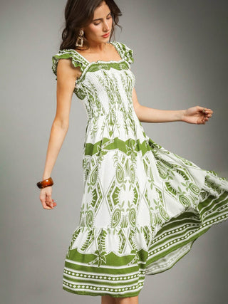 white and green patterned midi dress with a smocked bodice and flutter straps