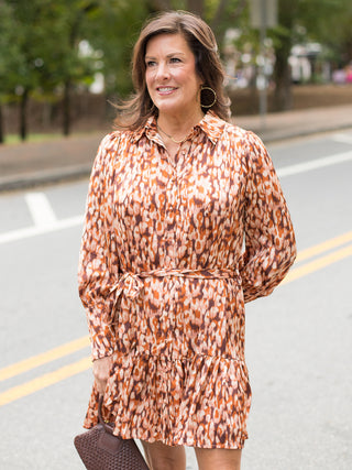 an orange printed long sleeve dress in lightweight fabric with an above the knee hemline perfect for fall and holiday events