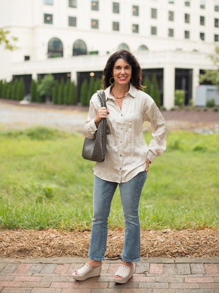 a shiny beige button down blouse in a relaxed silhouette with long sleeves perfect for everyday wear shown with denim pants
