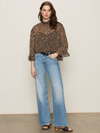 a sheer crinkled cheetah print blouse with ruffled three quarter sleeves worn with blue jeans