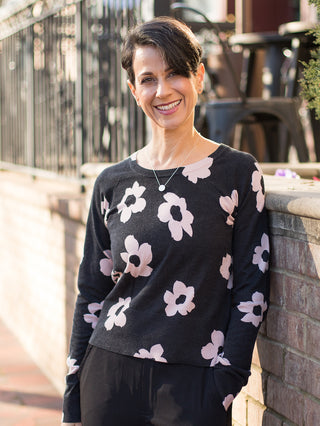 wear this light black sweater with pale pink florals and a crew neckline as feminine winter wear with black cargo pants