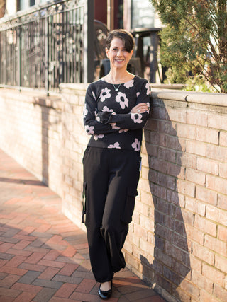 wear this light black sweater with pale pink florals and a crew neckline as feminine winter wear with black cargo pants