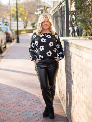 wear this light black sweater with white florals and a crew neckline as feminine winter wear with faux leather pants