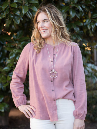 a dark pink linen button down blouse with long elastic cuffed sleeves 