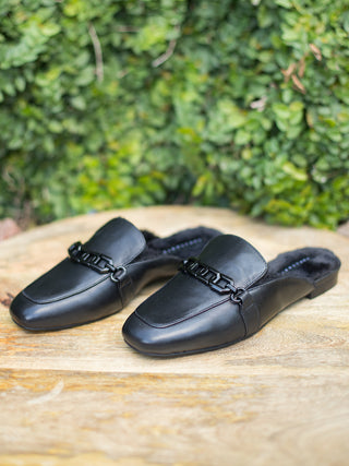 a pair of black faux leather loafer mules with furry lining and memory foam perfect for everyday chic fashion