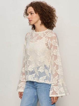 a romantic ivory long sleeve sheer blouse with a floral embellished pattern worn with light blue jeans