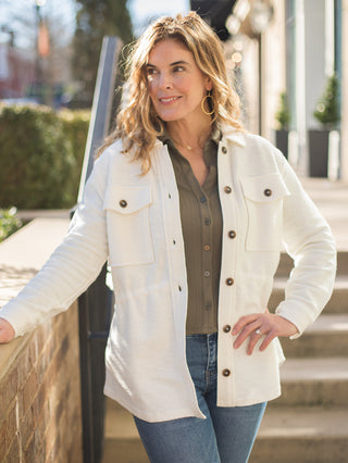 a cream collared shacket with brown buttons down the front 
