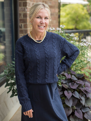a navy cable knit sweater in crop style with long sleeves perfect for layering