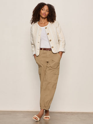 a chic lightweight puffer jacket with front buttons and off white stripes worn over a white tee
