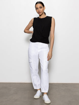 black sleeveless tank with cascading front detail and round neck paired with white pants