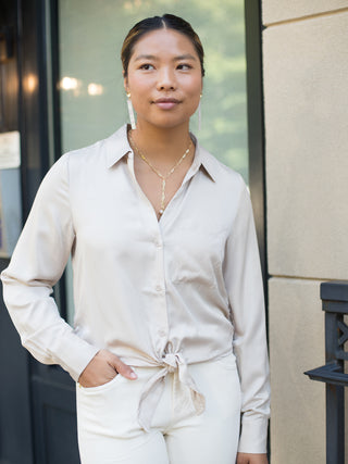 an ivory satin button down blouse that ties at the waist perfect for summer to fall dressing