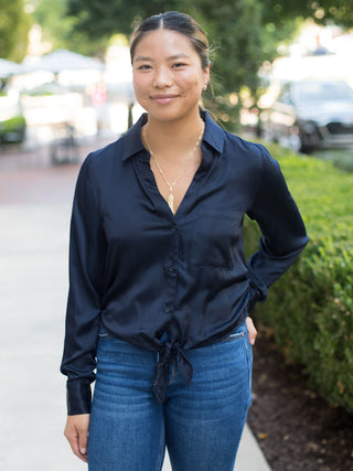 a navy satin button down blouse that ties at the waist perfect for summer to fall dressing