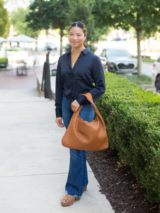 a navy satin button down blouse that ties at the waist perfect for summer to fall dressing shown with denim pants