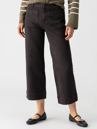 a pair of black cropped wide leg denim jeans