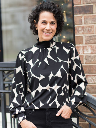wear this black and white retro print top with statement sleeves and feminine details to holiday parties
