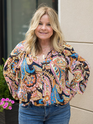 a multicolor paisley blouse with buttons down the front and dramatic sleeves perfect for transitional dressing