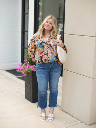 a multicolor paisley blouse and dramatic sleeves perfect for transitional dressing shown with denim pants