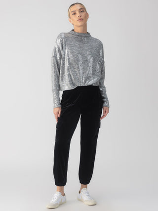 a fun pair of black velvet joggers with a relaxed fit and cargo pockets worn with a gray top