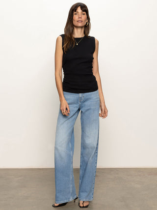 black ribbed crew neck tank top with side cinching paired with blue denim jeans