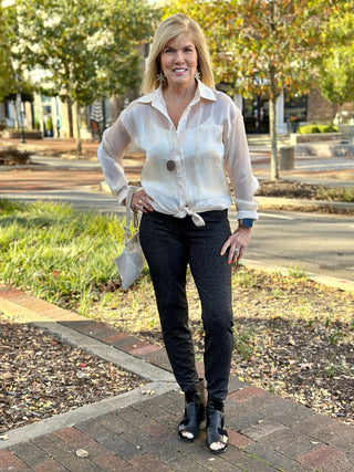 fun stretchy black knit legging pants worn with a cream colored blouse