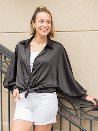 a black satin blouse in a relaxed fit with dramatic sleeves