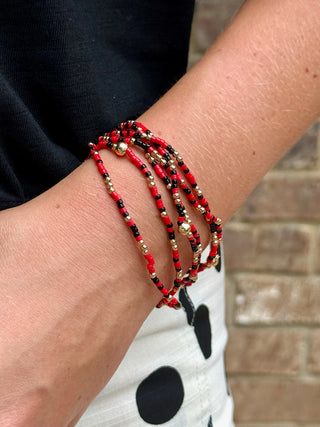set of six red and black with gold bead accents bracelets