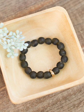 a black sea glass beaded bracelet with gold details great for everyday jewelry wear and small gifts