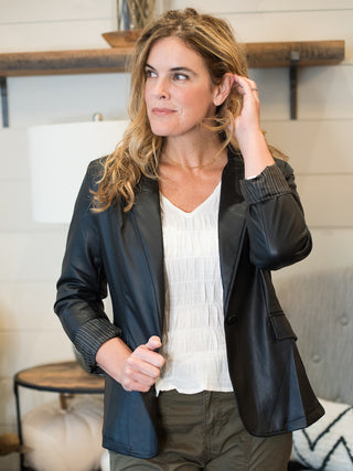 a black faux leather blazer with button details great for layering in a structured silhouette featuring girlboss vibes