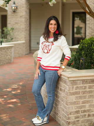 a white sweater with red trim and a sequin uga bulldog perfect for georgia football game day shown with dawgs earrings