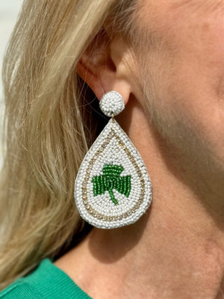 a pair of white and green beaded clover st patricks day dangle earrings