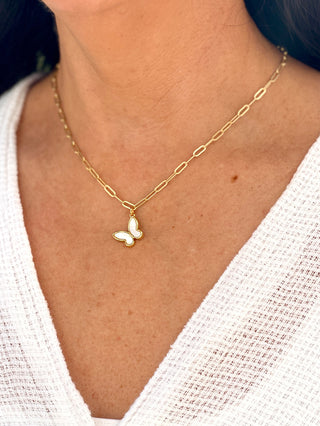 charming gold chain link necklace with a bright white butterfly pendant