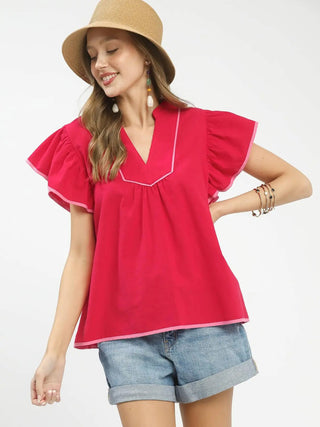 a red short sleeve ruffled top with a v neck and pink contrast piping