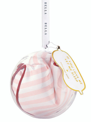 a plastic holiday ornament with a striped sleeping mask gift inside