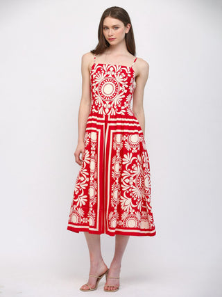 Red and white patterned dress on a model against a white background