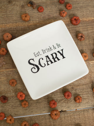 a small off white stoneware serving plate that reads eat drink and be scary in black type perfect for halloween decor